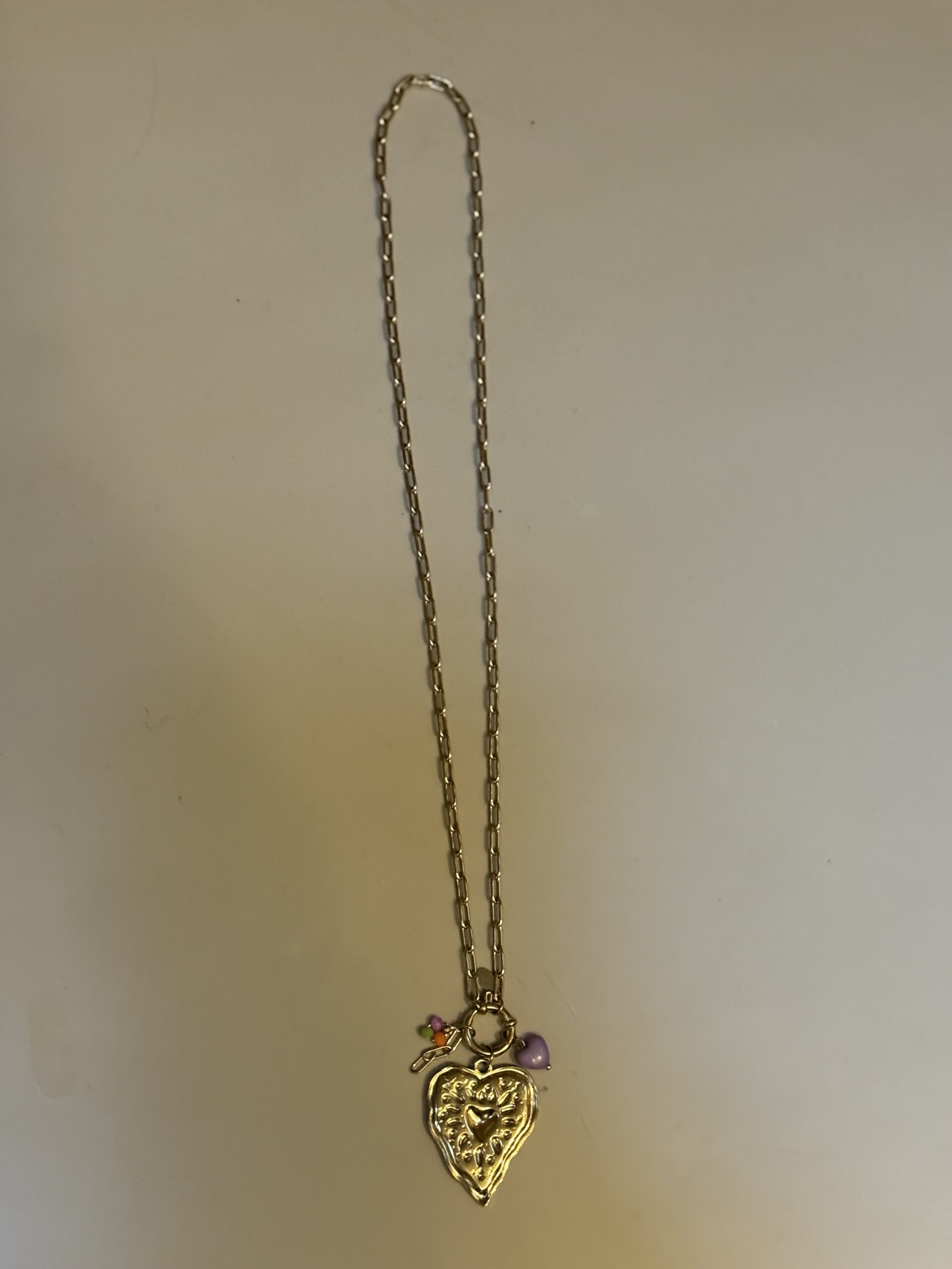 Lange goudkleurige ketting met hartbedel