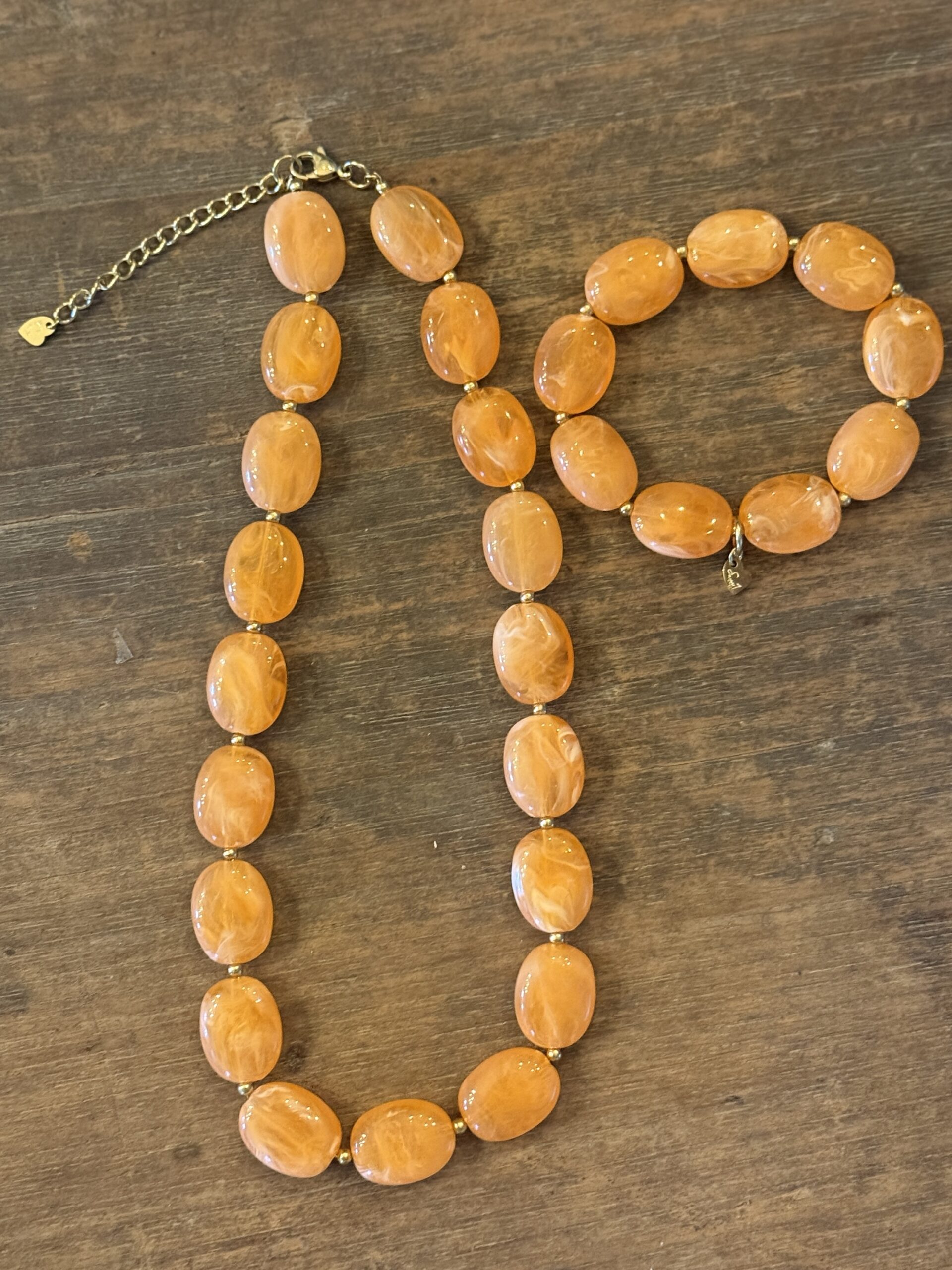 Oranje kralenketting met goudkleurige accenten