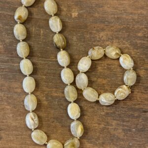 Zandkleurige kralenketting met goudkleurige accenten